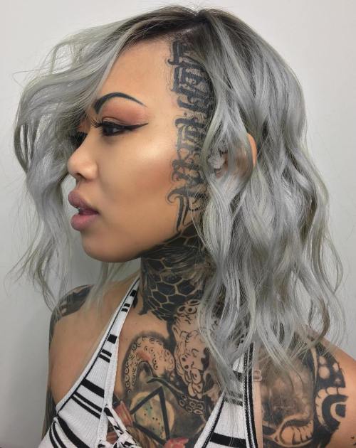 Medium wavy gray hairstyle with head tattoo